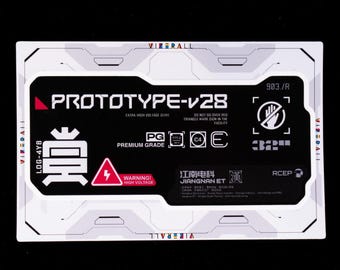 May include: A rectangular sticker featuring a black centre with white text reading PROTOTYPE-v28, PREMIUM GRADE, and WARNING! HIGH VOLTAGE. It includes a red lightning bolt icon, a no-touch symbol, and Chinese characters, all framed by a white border.