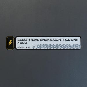 May include: A rectangular black and white label featuring a yellow lightning bolt icon on the left. The text reads ELECTRICAL ENGINE CONTROL UNIT / ECU and F/W Ver.. 4.02, accompanied by a grey circuit board pattern on the right side of the label.