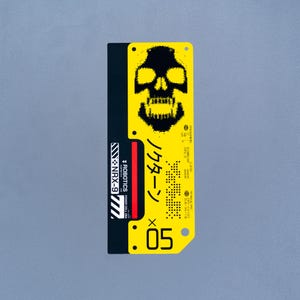 May include: A rectangular sticker featuring a black and yellow colour scheme. The top section displays a black pixelated skull graphic. Below, the text includes "ROBOTICS", "NRX-9", "05", and Japanese characters. The design incorporates technical specifications and industrial-style markings.