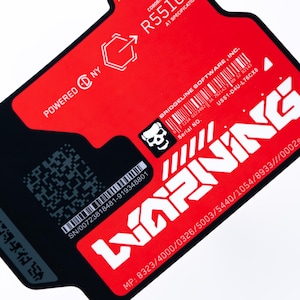 May include: A red and black rectangular label with white text and graphics. The label includes the word "WARNING" in large white letters, a skull graphic, and a barcode. Text includes "POWERED NY" and "BRIDGELINE SOFTWARE, INC."
