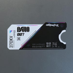 Peut inclure: Une carte d'identification rectangulaire au design divisé en blanc et noir. La section blanche affiche le texte 370KV, PS10 007 et un petit caractère chinois. La section noire comprend un code QR, un numéro de série et une découpe circulaire.
