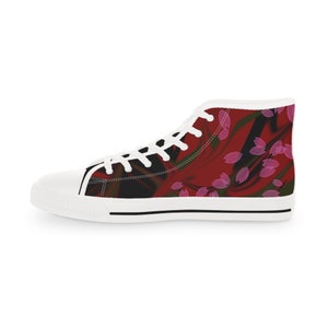 May include: A high-top sneaker featuring a white rubber toe cap, white laces, and a white sole with a thin black stripe. The canvas upper displays a dark red and black abstract background pattern overlaid with scattered, translucent pink petal shapes.