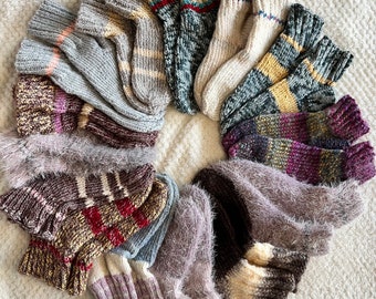 May include: A collection of colorful knitted socks in various patterns and textures, including fuzzy, striped, and speckled designs. The socks are arranged in a circle, creating a visually appealing display.