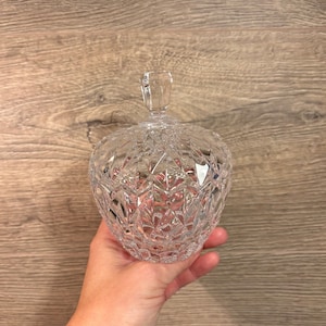May include: A clear glass candy dish with a diamond pattern. The dish has a lid with a knob on top.