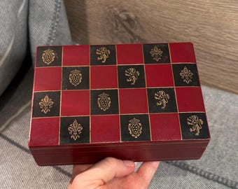Caja con bisagras vintage de cuero con diseño de león, escudo y flor de lis en negro y rojo, hecha en Italia. Elegante almacenamiento italiano. Decoración mediterránea para el hogar.