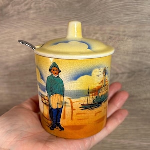 Tarro de mermelada de miel con tapa ranurada de cerámica vintage 'Un regalo de Birmingham' con diseño de pescador, faro y puesta de sol en color panal