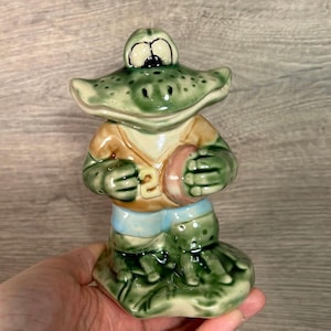 ヴィンテージスタジオアート陶器コレクター向け艶出しグリーンスポーツマンハッピーフロッグヒキガエル、大きな笑顔でボールを持ち、背番号22のTシャツを着ています
