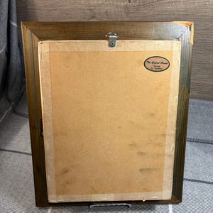 Puede incluir: Un marco de fotos de madera marr&oacute;n con un paspart&uacute; de papel marr&oacute;n y una etiqueta blanca con el texto "The Gifted Hand, Ramagh, Co. Tipperary".