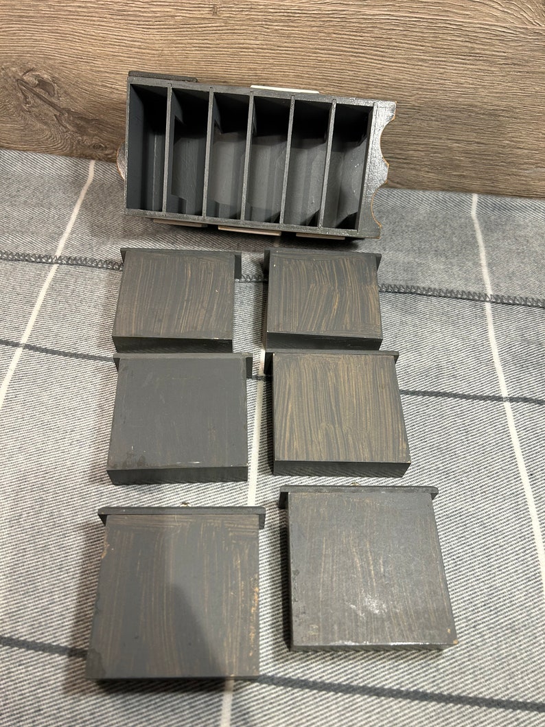 May include: Six small wooden boxes with a dark brown stain and a light brown wood grain pattern. The boxes are arranged in two rows of three. The boxes are empty and have a slightly distressed look.