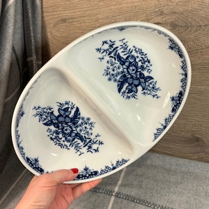 May include: A white oval serving dish with two divided sections. The dish is decorated with a blue and white floral pattern.