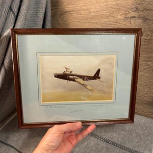 Peut inclure: Une estampe encadrée d'un bombardier vintage de la Seconde Guerre mondiale, avec le texte "F for Freddie" et "Wellington 1c" écrit sous l'image. L'estampe est signée par "Les Vance".