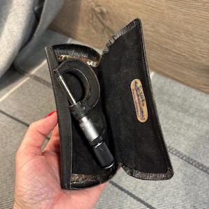 May include: A silver and black micrometer in a black leather case with the label "E.G.C.E." on the case.