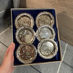 Vintage zilverkleurig metaal uit het midden van de eeuw, sierlijk versierd met reliëf en gegraveerde onderzetters gemaakt in Engeland, set van 6 | Retro drankentrolley