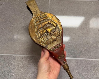 Fuelle de chimenea antiguo rústico, desgastado y patinado, con forma de velero repujado / Herramientas decorativas náuticas para chimenea, de madera, latón y cuero rojo.