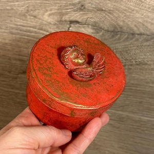 Joyero vintage de lujo con cabeza de ángel querubín y alas, redondo, con tapa circular, color rojo metálico dorado / Maceta de cartón con diseño de querubín