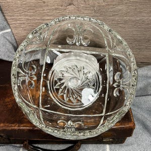 May include: A handmade wooden sign with the text "Welcome" in a whimsical font. The sign is painted white with a distressed finish and features a decorative floral design in shades of pink and green. It measures approximately 12 inches wide.