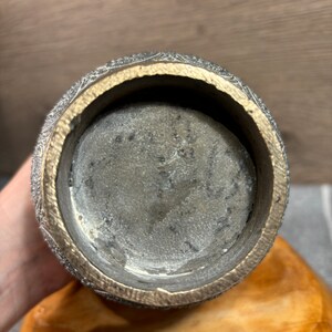 K&ouml;nnte beinhalten: Der Boden einer dekorativen Vase aus Silber und Gold mit einem komplizierten Design. Das Innere der Vase ist sichtbar und scheint aus einem dunkleren Metall zu sein.