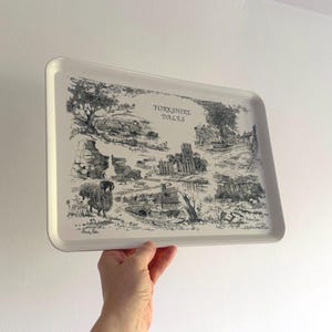 May include: A white rectangular serving tray featuring a black and white illustration of the Yorkshire Dales. The tray depicts a detailed landscape with trees, buildings, and sheep. The text "Yorkshire Dales" is printed on the tray.