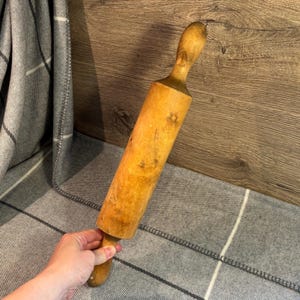 May include: A wooden rolling pin with a natural finish. The rolling pin is approximately 38 cm long and has a rounded handle.