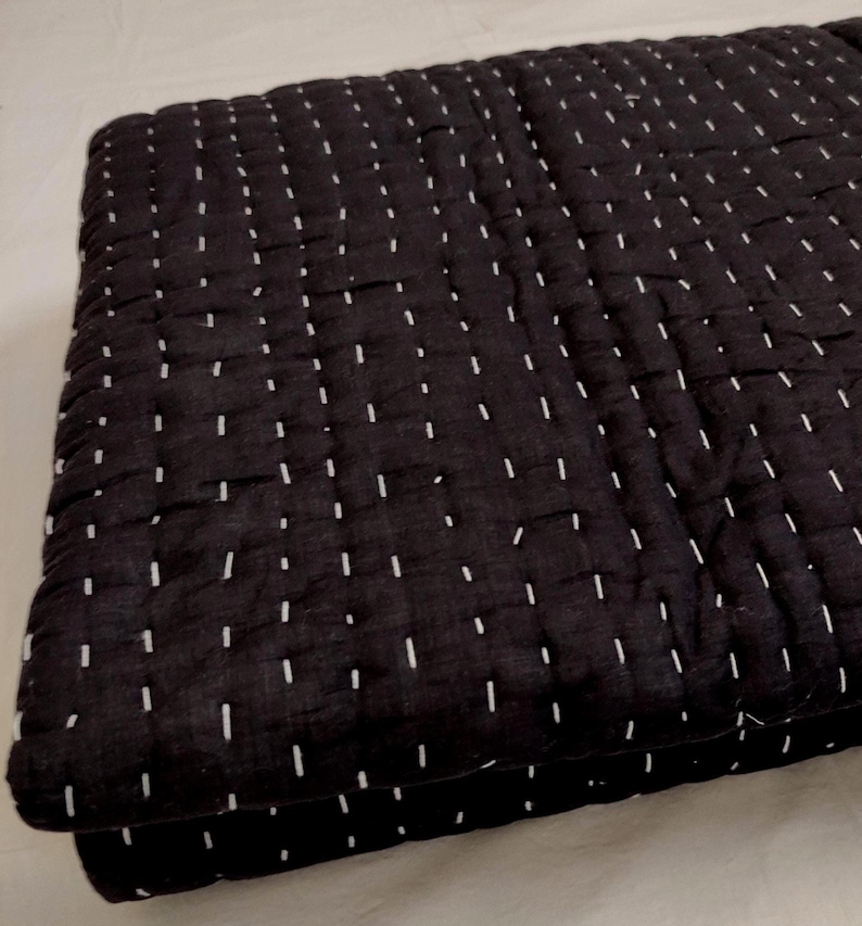 Queen Size black cotton quilt with fine white stitches.