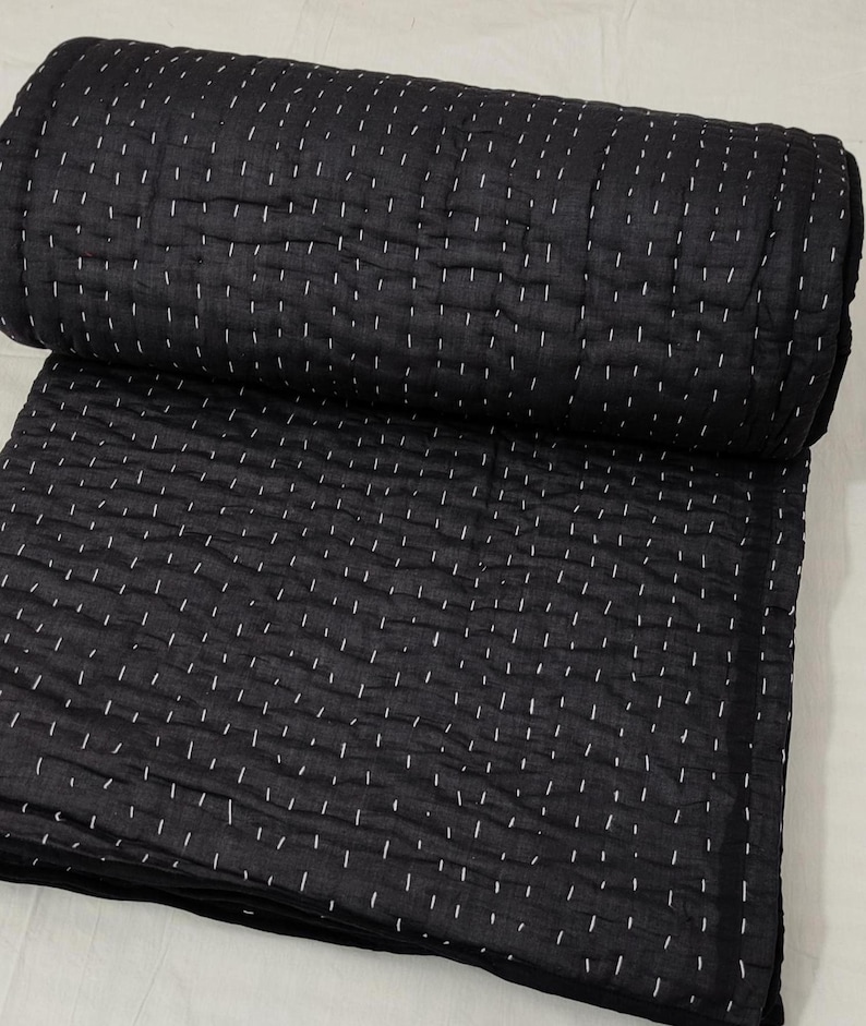 Minimalist black cotton quilt with traditional Kantha work.