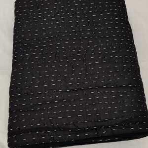 Traditional hand quilted throw blanket with minimalist stitching.