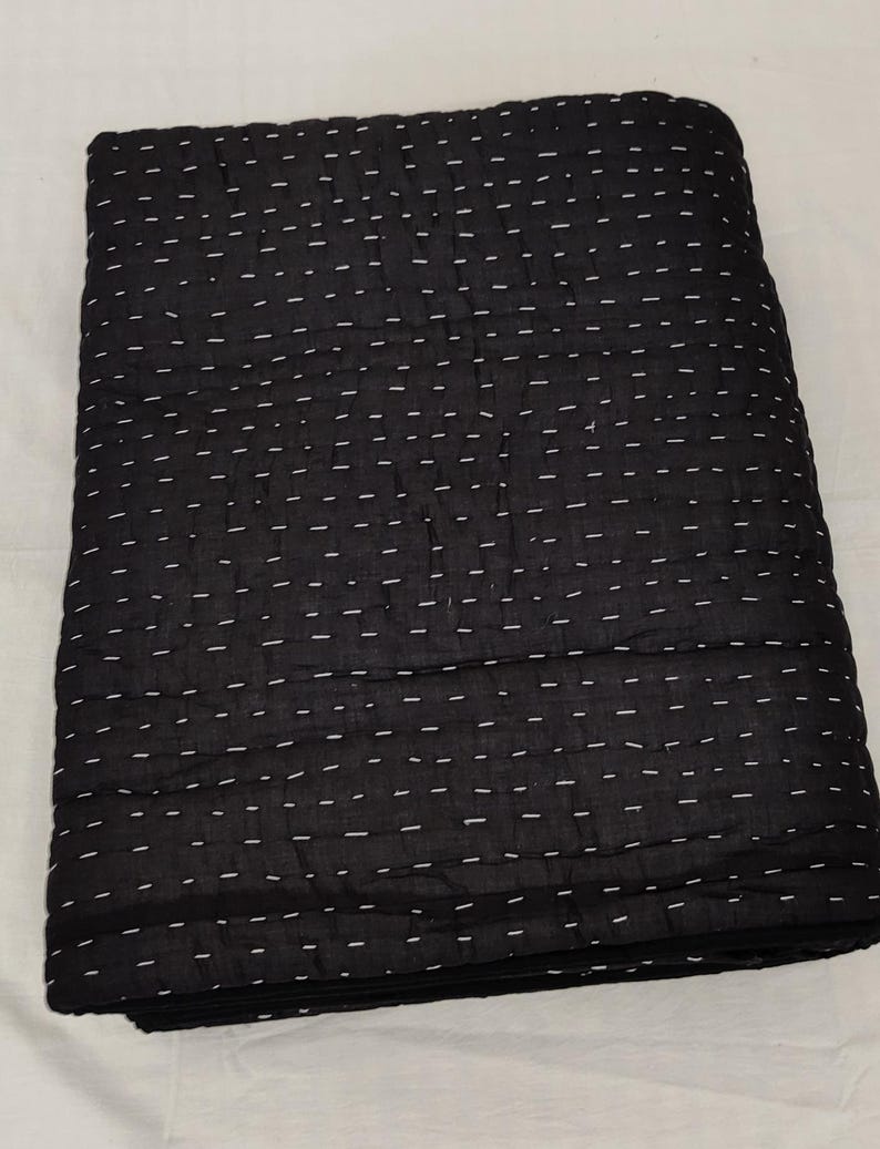 Traditional hand quilted throw blanket with minimalist stitching.