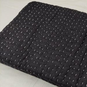 Black handstitched quilt with cozy textured cotton layers.
