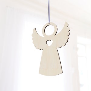 Könnte beinhalten: Ein hölzerner Engel-Anhänger mit einem Herz-Ausschnitt, der an einer blauen Schnur hängt. Der Engel ist hellbraun und hat ein schlichtes Design.