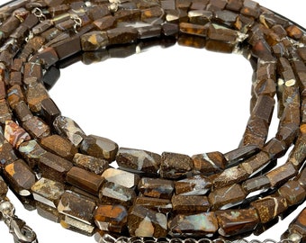 May include: A long strand of brown and white opal beads, with a silver clasp. The beads are rectangular and have a rough, natural texture.