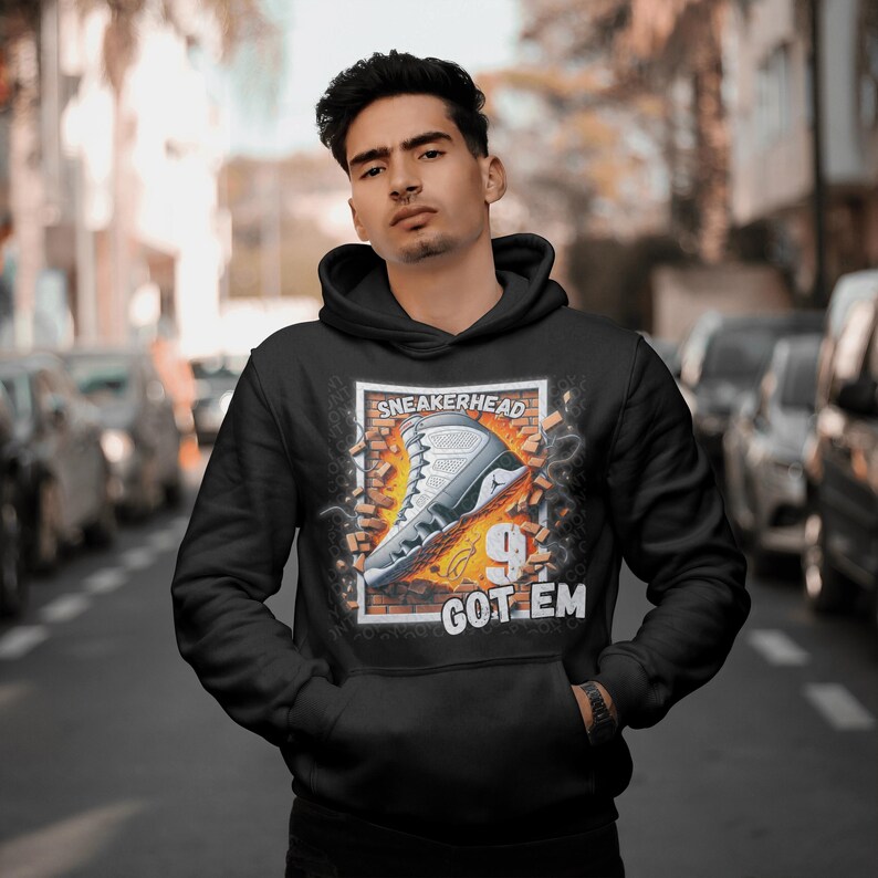 May include: Black hoodie with a graphic print of a white and grey sneaker breaking through a brick wall. The text "SNEAKERHEAD" and "GOT 'EM" are printed on the graphic.