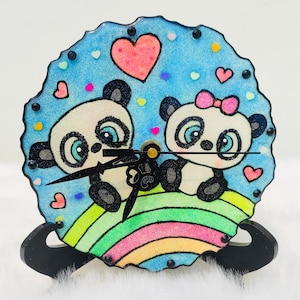Pandas en un reloj de resina arco iris