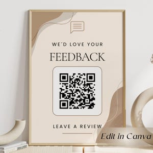 May include: A rectangular sign in a light beige frame featuring the text WE'D LOVE YOUR FEEDBACK and LEAVE A REVIEW in black font. A speech bubble icon sits above the text, and a large black and white QR code is centered on the beige background.