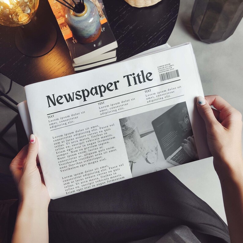May include: A black and white newspaper with the title "Newspaper Title" printed in bold, black font. The newspaper features text about Lorem ipsum dolor sit amet, consectetur adipiscing elit. The newspaper also includes a black and white photo of a laptop computer.