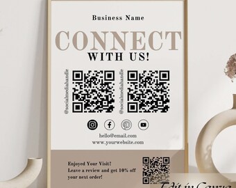 May include: A framed poster with a minimalist design featuring the text "Connect with us!" and two QR codes. The poster also includes social media icons for Instagram, Facebook, Pinterest, and YouTube. Below the QR codes is the text "hello@email.com" and "www.yourwebsite.com". The poster also includes a QR code and the text "Enjoyed your visit? Leave a review and get 10% off your next order!" The poster is framed in a light wood frame and is sitting on a table.