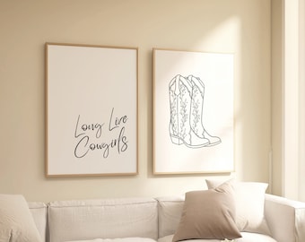 May include: Two framed prints on a white wall above a white couch. The print on the left says "Long Live Cowgirls". The print on the right features a line drawing of two cowboy boots with floral designs.