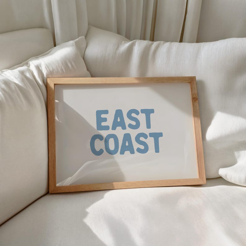 Minimalist typography wall art featuring the words “East Coast” in soft blue lettering on a clean off-white background. A modern, coastal-inspired print perfect for beach house decor, summer homes, living rooms, bedrooms or relaxed contemporary spaces. The simple design and airy colour palette create an effortless, laid-back seaside feel. This listing is for a digital download only. No physical print or frame included.