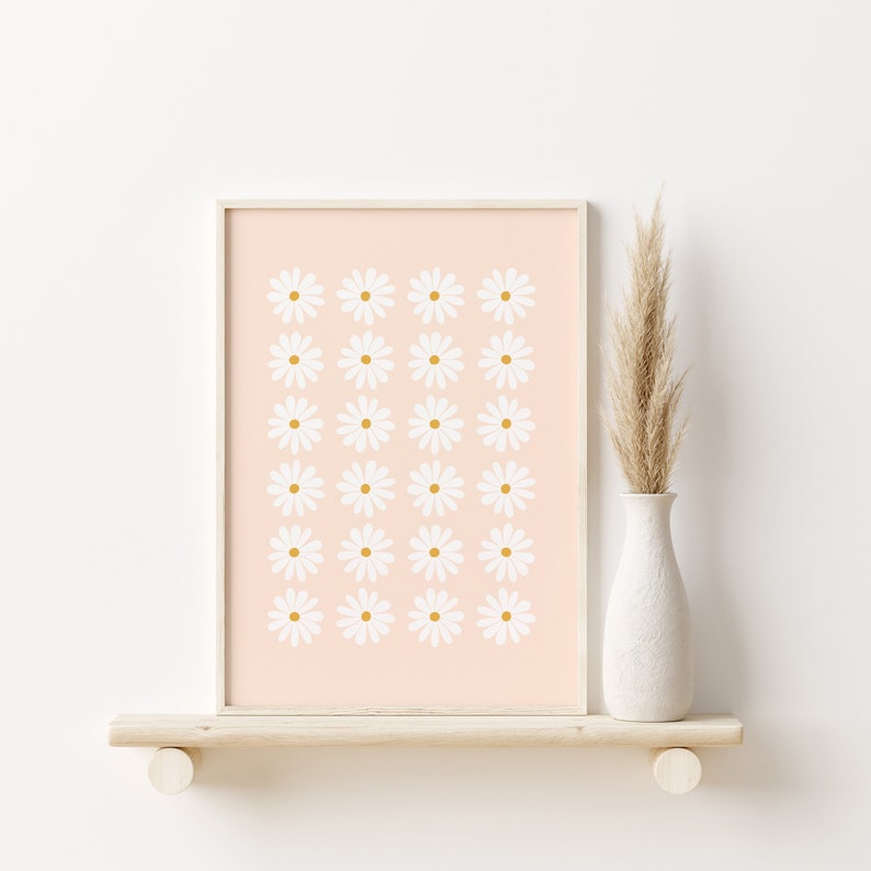 May include: A framed print with a pink background and a repeating pattern of white daisies with yellow centers.