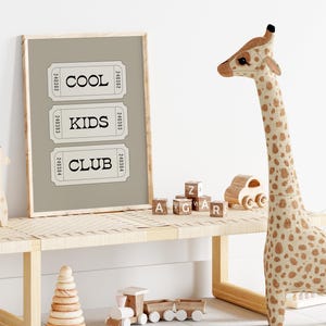 Typography wall art featuring three stacked ticket style designs with the words “Cool Kids Club” in bold black lettering on a neutral taupe background. Minimalist modern graphic print with a playful, retro inspired feel. This listing is for a digital download only. No physical print or frame included.
