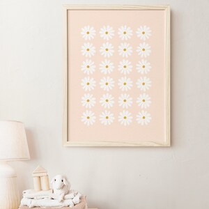 May include: A framed print with a pink background and a pattern of white daisies with gold centers.