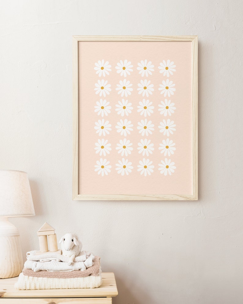 May include: A framed print with a pink background and a pattern of white daisies with gold centers.