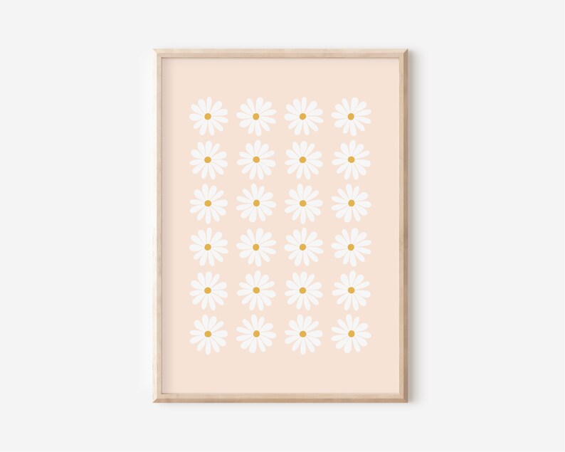 May include: A digital print of a pattern of white daisies with yellow centers on a peach background. The print is framed in a light wood frame.
