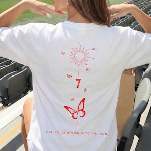 K&ouml;nnte beinhalten: Wei&szlig;es T-Shirt mit rotem Sonnen- und Schmetterlingsdesign. Das Design beinhaltet die Zahl 7 und den Satz "I'LL FOLLOW YOU INTO THE SUN". Das Shirt ist ein l&auml;ssiger Stil.