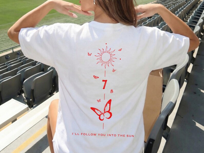 K&ouml;nnte beinhalten: Wei&szlig;es T-Shirt mit rotem Sonnen- und Schmetterlingsdesign. Das Design beinhaltet die Zahl 7 und den Satz "I'LL FOLLOW YOU INTO THE SUN". Das Shirt ist ein l&auml;ssiger Stil.