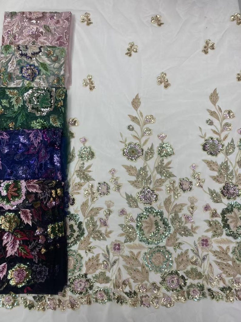 May include: A selection of embroidered fabrics in various colors, including pink, green, and navy blue. The fabrics feature floral and leaf designs with sequins and beads, and are displayed against a white background.