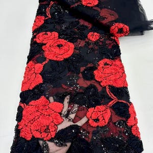 May include: Black mesh fabric with red 3D floral embroidery and sequins.