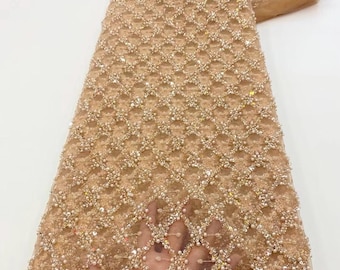 May include: A beige beaded lace fabric with a geometric pattern. The fabric is embellished with sequins and pearls.