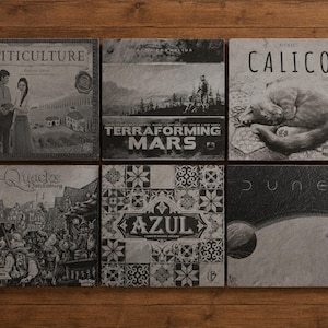 Slate coasters engraved with popular board game inspired designs displayed as a complete collection.