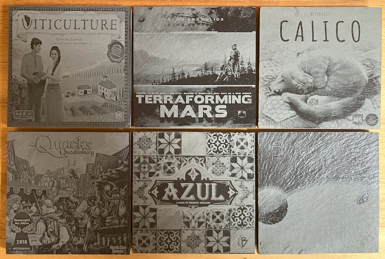 May include: Six different board game boxes with black and white images. The boxes are arranged in two rows of three. The top row features the games "Viticulture", "Terraforming Mars", and "Calico". The bottom row features the games "Quacks of Quedlinburg", "Azul", and a game with a black and white image of a wave.