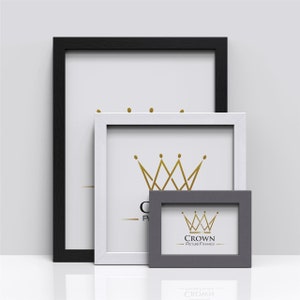 May include: Three picture frames in different sizes, arranged together. The frames are black, white, and grey, with a white background. Each frame features a gold crown logo and the text "Crown Picture Frames".